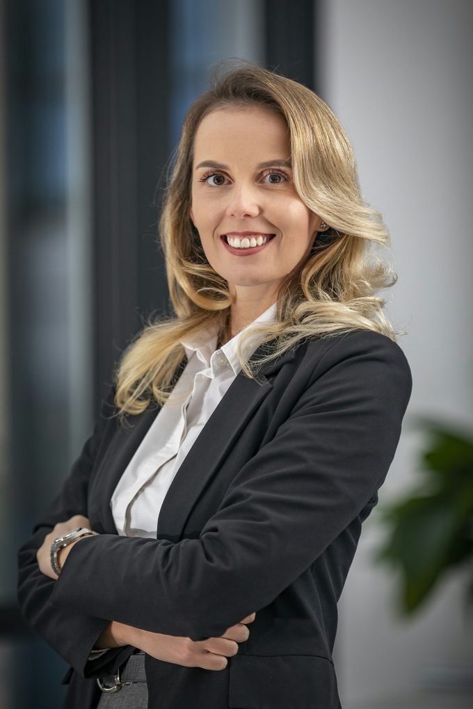 Leende blond kvinna i mörk kavaj med armarna i kors, headshots Stockholm