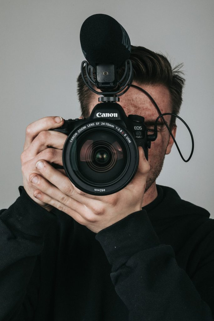 Modellfotograf Andreas Eriksson håller kameran framför ansiktet