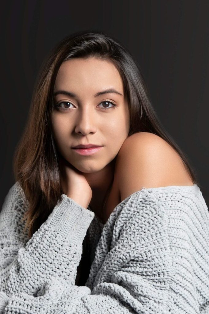 Mörkhårig kvinna i grå stickad tröja i studio, modellfotograf Stockholm
